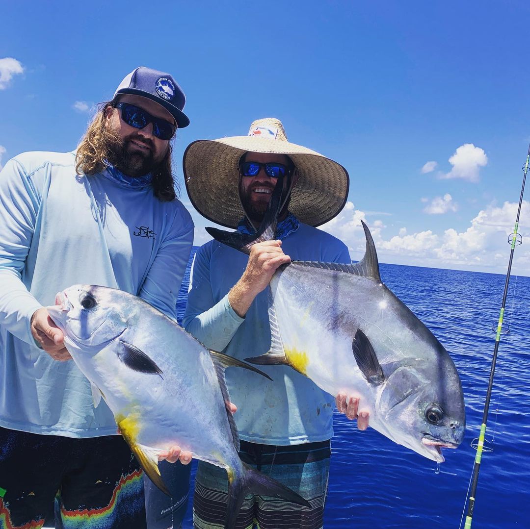 Captain Jason Stock showing off a kingfish with some storm clouds in the background.